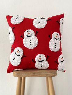 a red pillow with snowmen on it