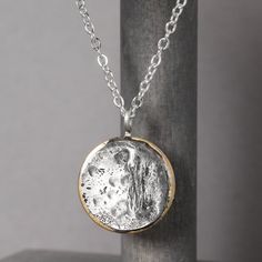 In 2017, the solar eclipse's path of totality found its way to Casper, Wyoming and sparked pure magic. Our Solar Eclipse Necklace is meant to do just that. Inspired by the celestial spectacle, we hope this handmade piece reminds you to look up and see the world through new eyes from time to time. Handcrafted with love in the heart of Wyoming. Necklace Details Pewter & Brass Charm on a dainty bail Sterling silver chain - choose your length Includes jewelry care card & polishing pad Free standard Artisan Moon Phase Jewelry In Moon Shape, Artisan Moon Charm Necklaces, Celestial Hand Forged Necklace Gift, Artisan Moon Phase Jewelry Gift, Unique Coin-shaped Pendant Jewelry, Round Brass Necklace With Moon Phase, Handmade Moon Shaped Necklace, Unique Coin Pendant Necklace, Handmade Unique Moon Necklace