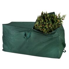 a large green bag filled with plants on top of a white background