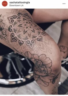 a woman's legs with tattoos on them and flowers in the middle of her leg