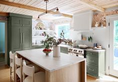 a kitchen with green cabinets and white counter tops