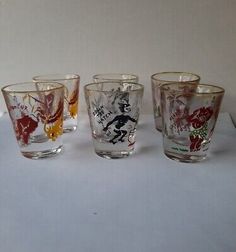 four glass cups with different designs on them