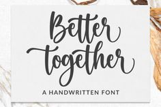 a handwritten font that says better together on the side of a white paper with dried leaves