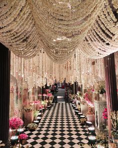 a black and white checkerboard floor with chandeliers hanging from the ceiling