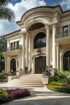 a large house with steps leading up to the front door and landscaping on either side