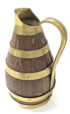 a wooden and brass striped pitcher on a white background