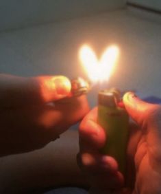 a person holding a lighter in their hand with the light on it's side