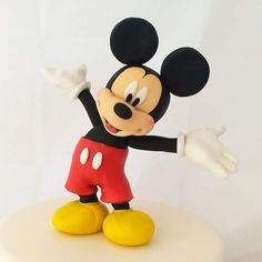 a mickey mouse figurine on top of a cake