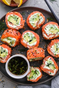 salmon and avocado rolls on a plate with dipping sauce