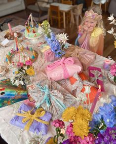 a table topped with lots of different types of flowers and gift boxes on top of it