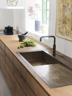 a kitchen with a sink, counter top and window in the back drop off area