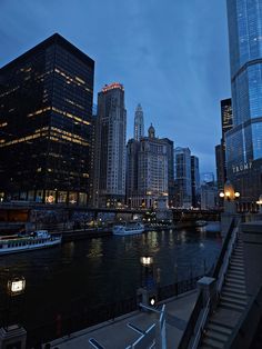 the city skyline is lit up at night with boats in the water and skyscrapers