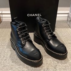 This Is An Authentic Pair Of Chanel Calfskin Grosgrain Chain Lace Up Cc Short Boots Size 38.5 In Black. These Stylish Lace-Up Boots Are Crafted Of Calfskin Leather In Black. They Feature A Black Rounded Leather Cap Toe With Threaded Chain Details. Never Been Worn. Only Tried On. Comes With Original Box And Dust Bag. Purchase From Neiman Marcus Chanel Black Ankle Boots, Formal Boots With Chain And Round Toe, Leather Boots With Chain Strap And Round Toe, Chanel Rain Boots, Chanel Combat Boots, Rain Boot Outfit, Suede Combat Boots, Shoes Chanel, Chanel Boots