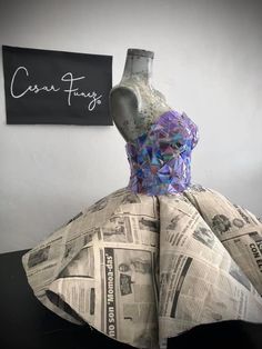 a dress made out of newspaper sitting on top of a table