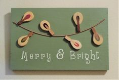 a merry and bright sign hanging from a line with scissors on it's side