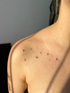 the back of a woman's shoulder with small black dots on it