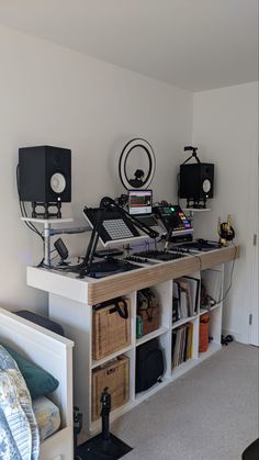 there are many electronic equipment on the shelf in this room and it looks like they have been set up for recording