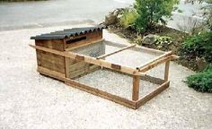 a chicken coop in the middle of a gravel area