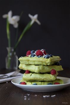 three waffles stacked on top of each other with berries and blueberries