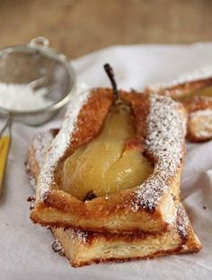 two pieces of bread with powdered sugar on them and an apple in the middle