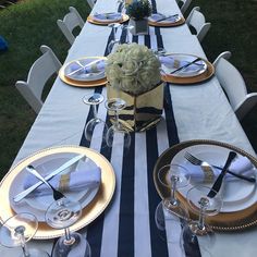 the table is set with plates, silverware and flowers in vases on it