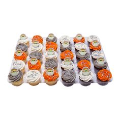 an assortment of cupcakes with orange frosting and white frosting on them