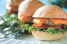 two hamburgers sitting on top of a white plate