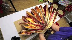 a woman is holding a large metal object in her hands and it looks like a flower