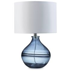 a blue glass table lamp with a white shade on the top and bottom part of it