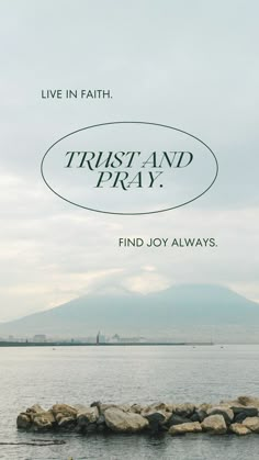 a poster with the words trust and pray on it in front of a body of water