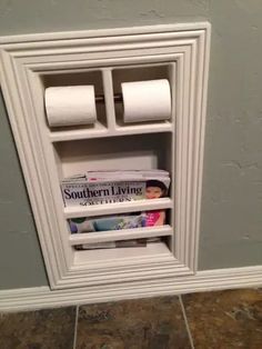 a magazine rack with two rolls of toilet paper in it