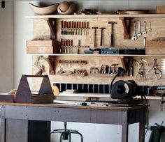 a workbench filled with lots of tools and woodworking implements on shelves above