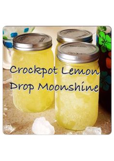 two jars filled with lemon liquid sitting on top of a counter