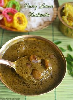 curry leaves and rice in a bowl with a spoon on the table next to it