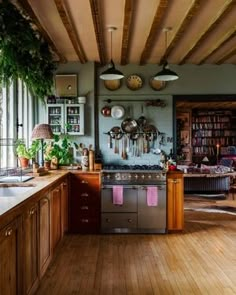 a kitchen with wooden floors and lots of hanging pots