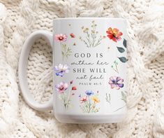 a coffee mug with flowers painted on it and the words, god is mother he she will not feed