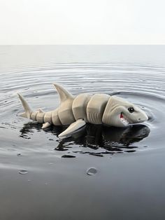 a toy shark in the water with its mouth open