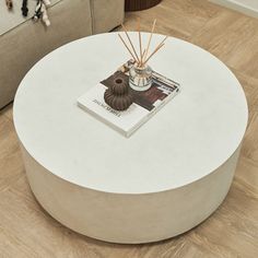 a white coffee table sitting on top of a hard wood floor next to a couch