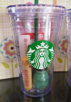 the starbucks cup has some pens and markers in it