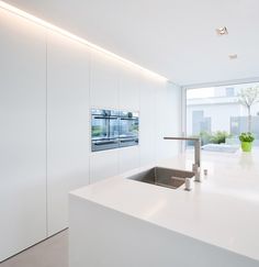 a kitchen with white counter tops and stainless steel faucet