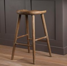 a wooden stool sitting on top of a hard wood floor next to a kitchen counter