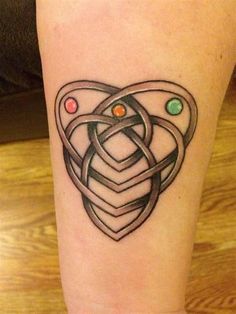 a tattoo on the leg of a person with a heart and two circles in it