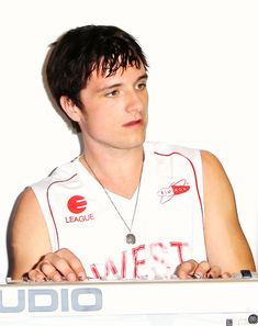 a young man sitting in front of a laptop computer with his hands on the keyboard