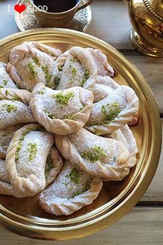 several pastries on a gold plate next to a cup of coffee