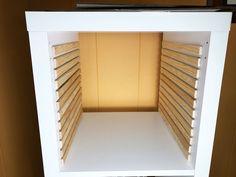 an empty white shelf with wooden slats on it