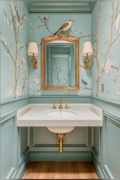 a bathroom sink with a bird on the mirror above it and wallpaper behind it