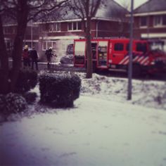 two firetrucks parked in front of a building with snow on the ground