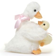 two stuffed ducks are sitting next to each other on a white background with pink ribbon