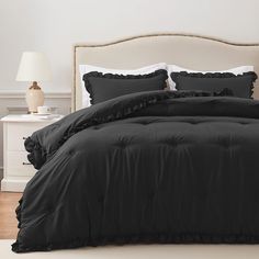 a black comforter with ruffled edges on a bed