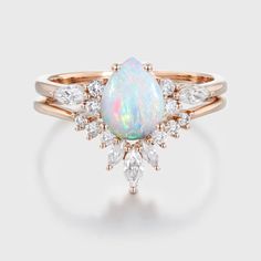 a white opal and diamond ring with rose cut diamonds on the side, set in yellow gold